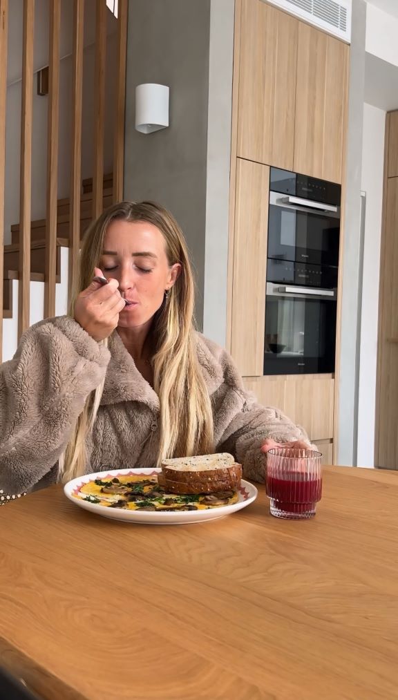 Rebecca Gawthorne taking a bite of the mushroom and herb omelette from the Lorna Jane Nourish Cookbook